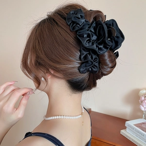 Elegant large black satin pleated hair claw clip shown on model's hair for sophisticated styling