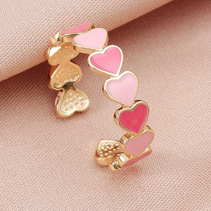 Anello regolabile a forma di cuore in oro con smalto rosa su sfondo morbido