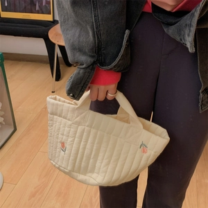 Quilted beige storage tote bag featuring red tulip embroidery and woven handles