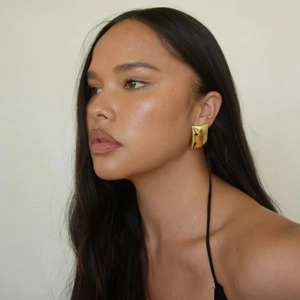Polished 18k gold plated geometric earrings featuring a wavy origami design on model