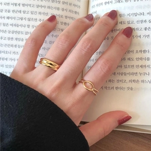 Close-up of minimalist gold S925 silver rings with geometric oval knot and thick band