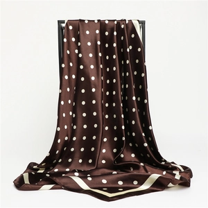 Dettaglio di un foulard quadrato marrone a pois bianchi in seta satinata liscia