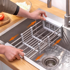 Adjustable stainless steel sink drying rack shown being extended over a kitchen basin