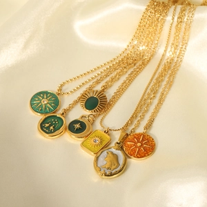 Vintage gold plated stainless steel necklaces with enamel pendants on white silk background
