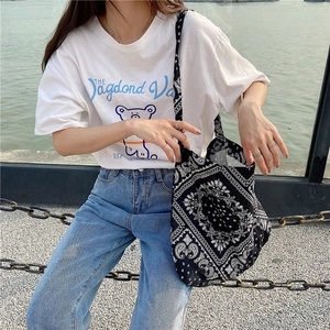 Detail of a casual canvas crossbody bag with vintage black and white paisley pattern