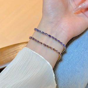Macro shot of gold and silver zircon tennis bracelets with purple oval gemstones
