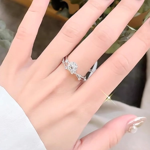 Sparkling silver vine ring with round moissanite on finger, soft nature background
