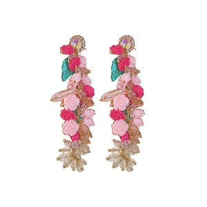 Floral crystal tassel earrings with pink resin roses and green leaves on white background