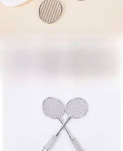 Dettaglio di due mini racchette da badminton argentate per borse o accessori per bambole