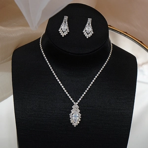 Macro shot of silver bridal necklace and marquise zircon drop earrings on a black neck model