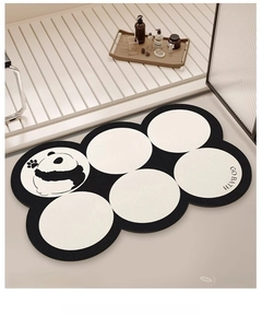 Detail of diatom mud bath mat with panda design and GO BATH text on wooden floor