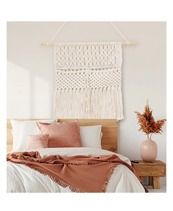 Detailed view of bohemian hand-woven cotton wall hanging with wooden beads in bedroom