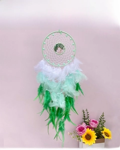 Detail view of handmade tree of life dreamcatcher with gradient green feathers and crystals