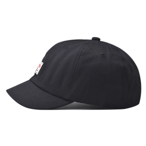 Detailed side view of black short brim cotton baseball cap with embroidered square label