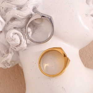 Artistic close-up of gold and silver fingerprint signet rings on white plaster base