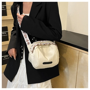 Detail of waterproof nylon crossbody bag with ethnic style wide strap and PU leather finish
