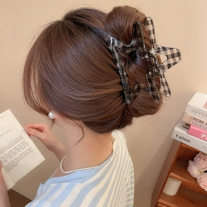 Star shaped acrylic checkered claw clip shown in a stylish updo on a female model
