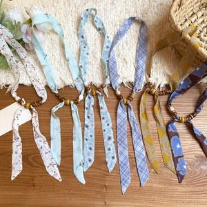 Detailed view of chiffon neck strap necklaces with colorful prints and natural wooden beads