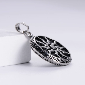 Macro shot of vintage sunburst pattern and side geometric engraving on steel pendant
