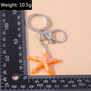 Detail view of orange glitter starfish keychain with lobster clasp and weight 10.5g