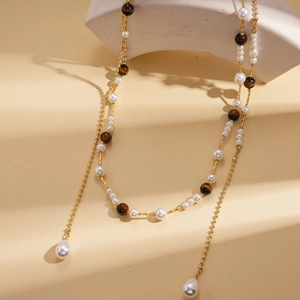Detail of long gold chain with tiger eye beads and water drop pearl pendants
