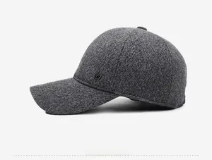 Detail view of dark grey wool-blend baseball cap with square metal side emblem