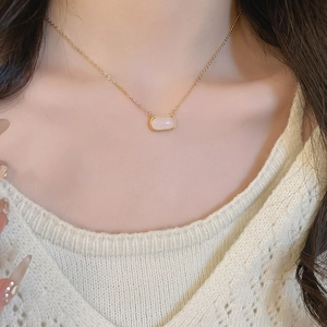 Détail du collier plaqué or 18k avec pendentif carré en résine rose porté par un mannequin