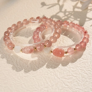 Detailed macro shot of pink strawberry quartz beads and golden spacer beads on two bracelets