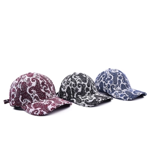 Trois casquettes de baseball à motif paisley en bordeaux, noir et bleu sur fond blanc