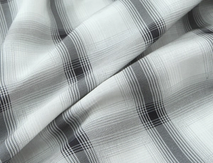 Close-up of grey and white plaid fabric texture showing soft drape and fine weave