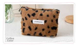Detail view of leopard print plush cosmetic bag featuring a Love Youth brand label
