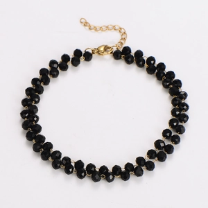 Detail showing double-strand black beaded necklace with gold clasp and adjustable chain