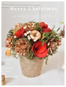 Close-up of Christmas tabletop decoration with red roses and golden pine cones in a linen pot