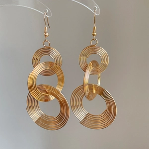 Elegant gold layered hoop dangle earrings with concentric circles in a bohemian style