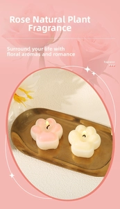 Detailed view of pink and white cat paw scented candles on an elegant golden tray
