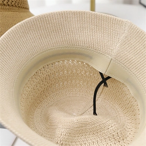 Detail view of the breathable hollow knit sun hat featuring adjustable black chin strap