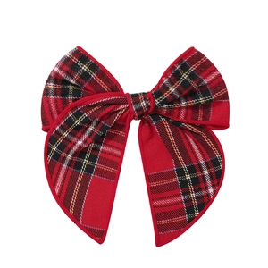 Dettaglio del grande fiocco a coda di rondine in tartan rosso per capelli stile natalizio