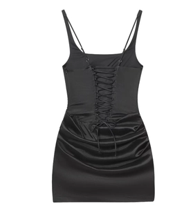 Detail view of the sleek black satin mini dress with crisscross tie-back and ruched sides