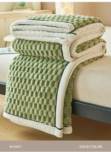 Close-up of thick green and cream blanket with bubble texture on a cozy bed