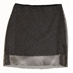 Detailed view of black mesh mini skirt with sparkling rhinestones and wide mesh hemline