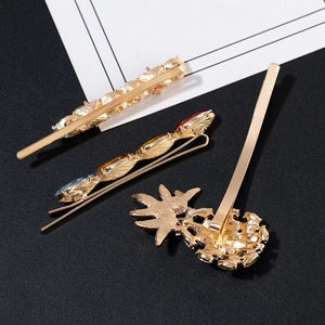 Vintage gold hair clip set with blue and red gemstones and a pineapple-shaped metal pin