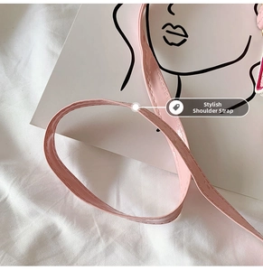 Close-up of pink glossy patent leather shoulder strap with neat stitching details
