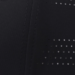 Dettaglio macro dei fori laser traspiranti e delle cuciture del berretto sportivo nero