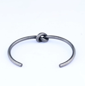 Retro stainless steel open cuff bracelet featuring a unique vintage wire knot design