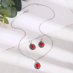 Détail macro du collier et des boucles d'oreilles sertis de pierres rouges sur argent