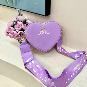 Macro detail of purple heart-shaped leather crossbody bag with patterned wide strap