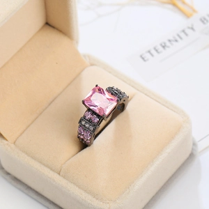 Macro shot of rectangular pink gemstone ring with black plating and pave crystals