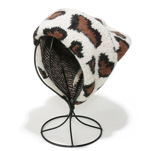 Dettaglio del berretto in maglia leopardata con trama elastica morbida su supporto metallico