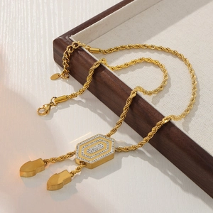 Luxurious gold-plated hexagonal pendant necklace with crystals on a jewelry display tray