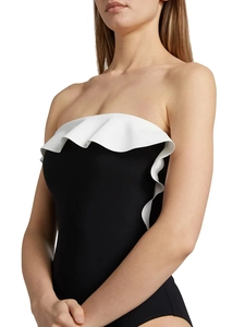 Détail d'un maillot de bain noir élégant avec de grands volants blancs au décolleté